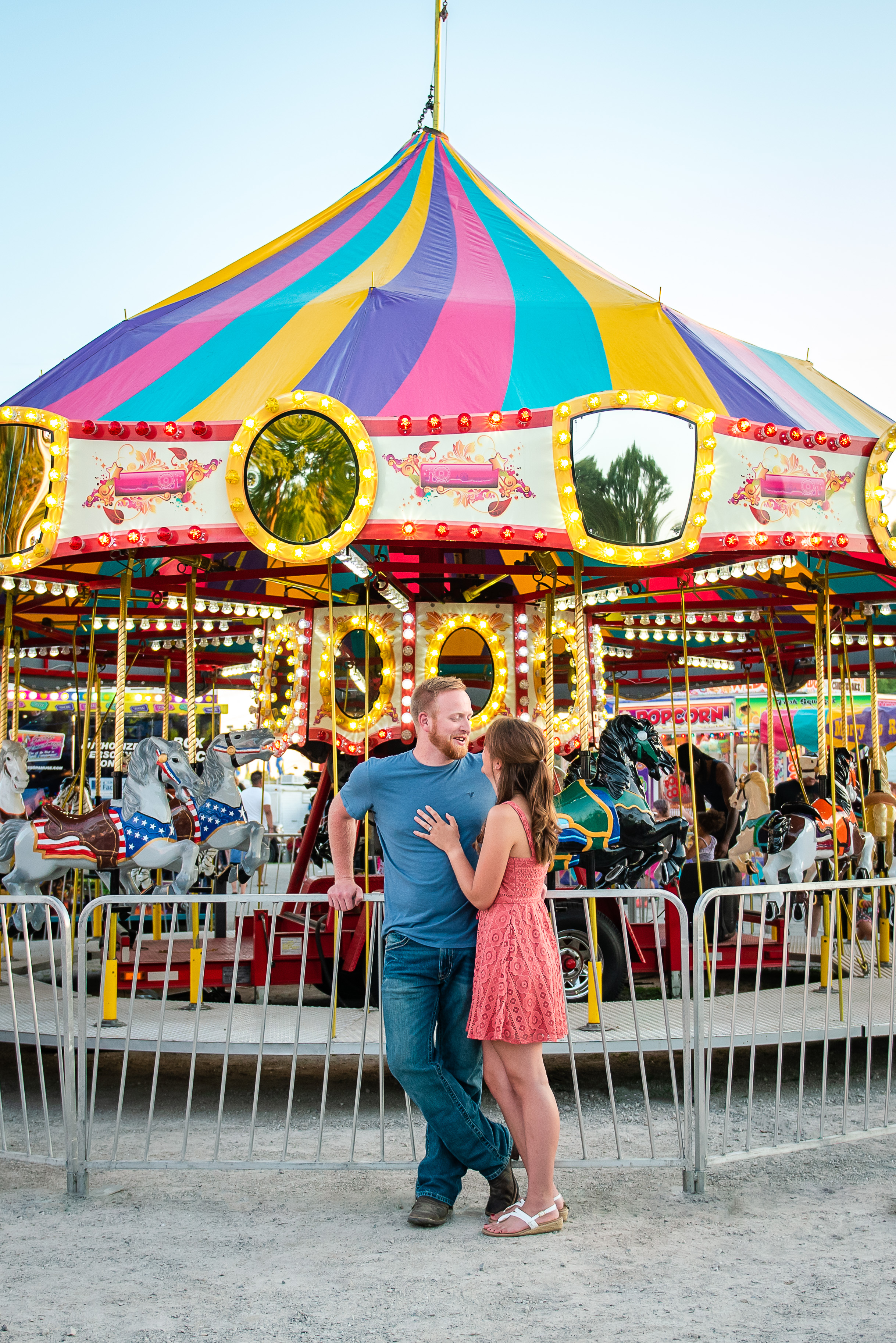 Couple standing beside fair carousel