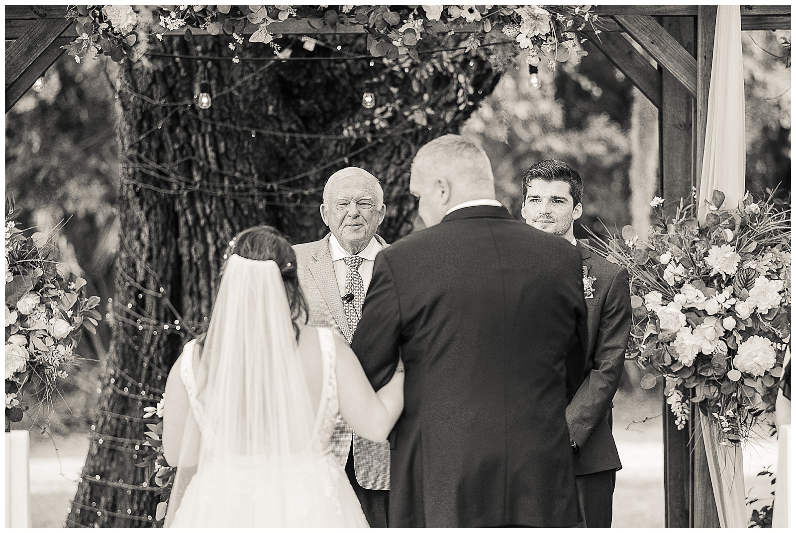 The brides grandpa and officiant and the groom looking lovingly at the bride as her father walks down the aisle 