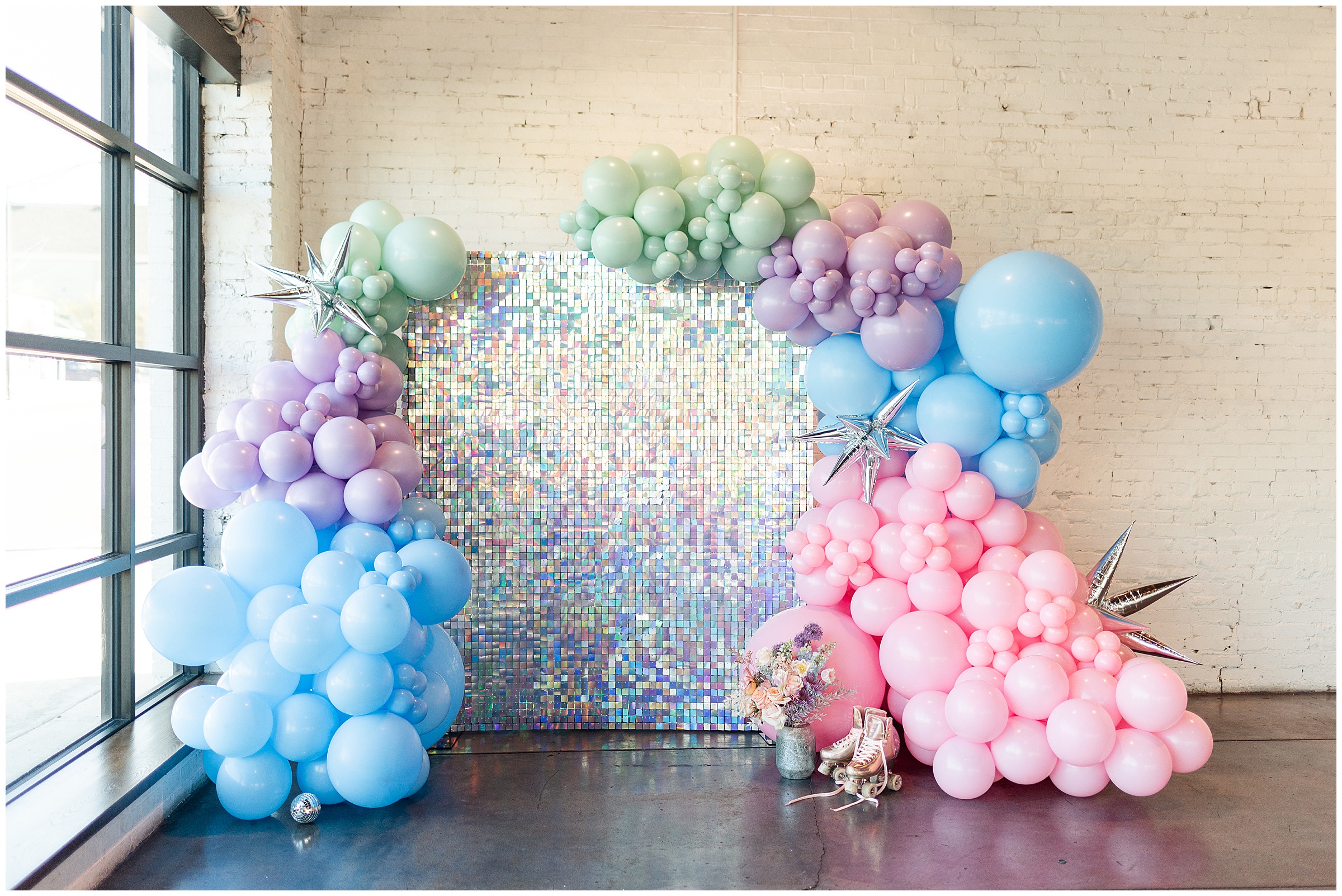 Pastel colored balloon arch with iridescent background