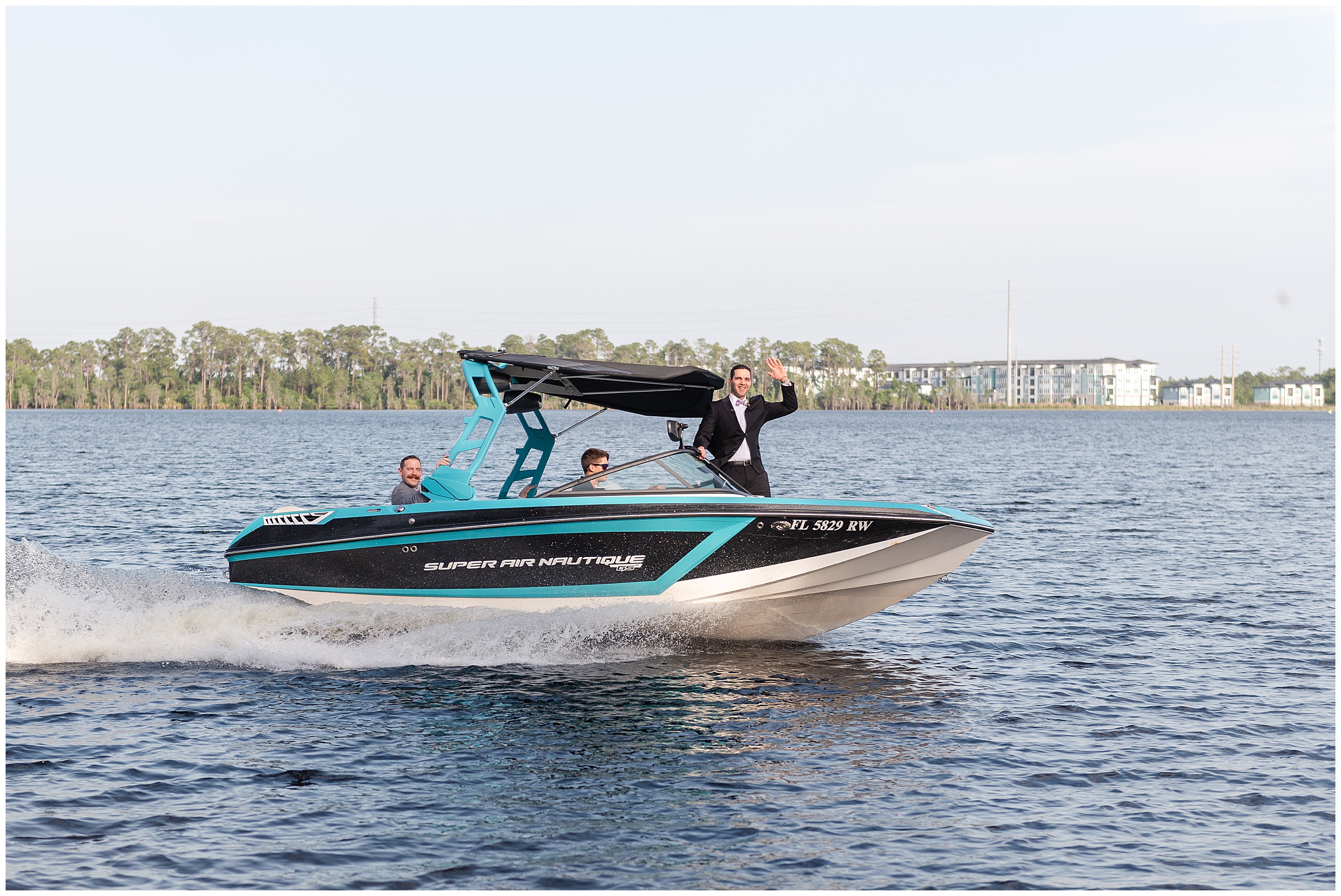 Groom riding into the ceremony on a boat at a Paradise Cove Wedding in Orlando, FL