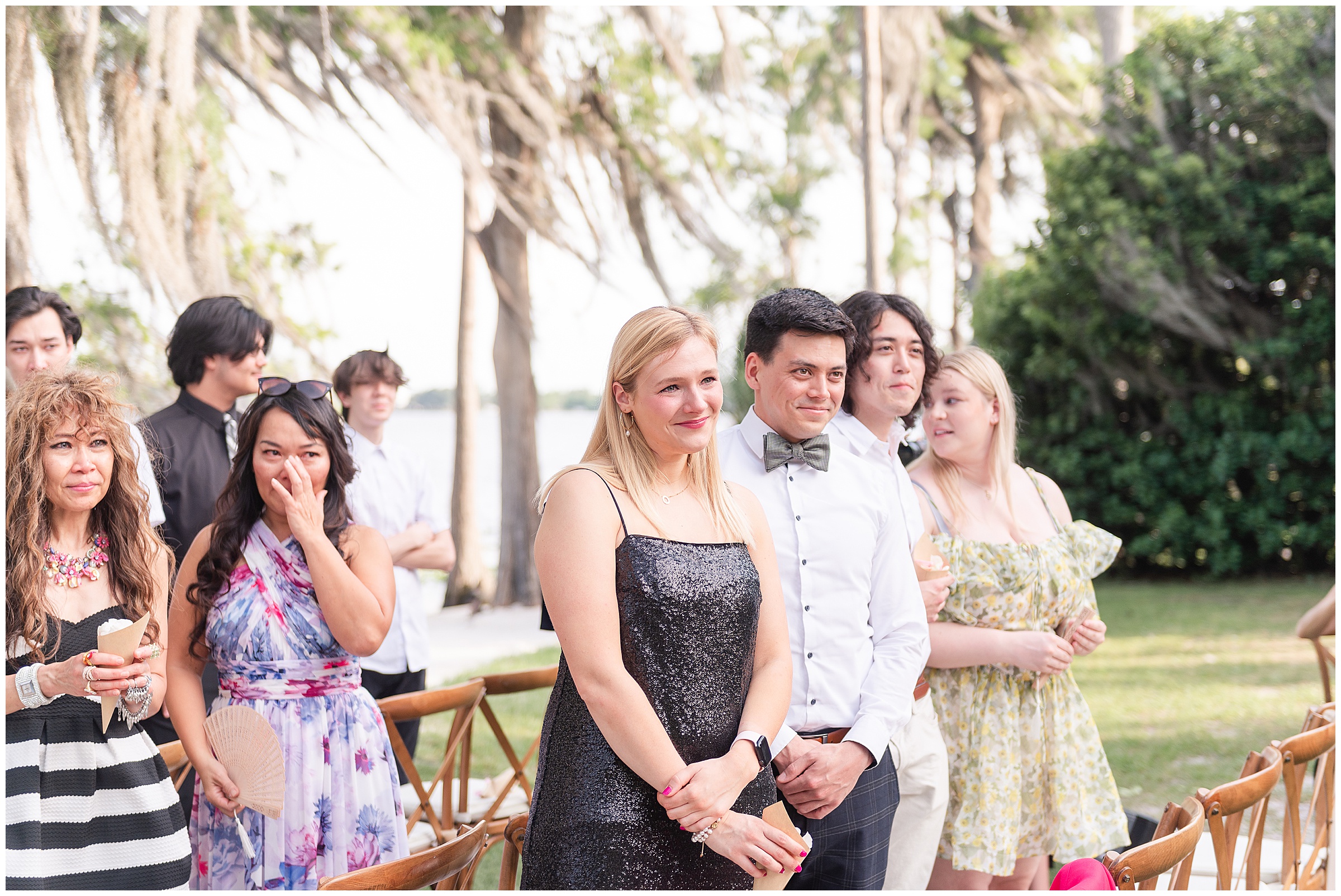 Guests happily crying watching the bride walk down the aisle at a Paradise Cove Wedding in Orlando, FL