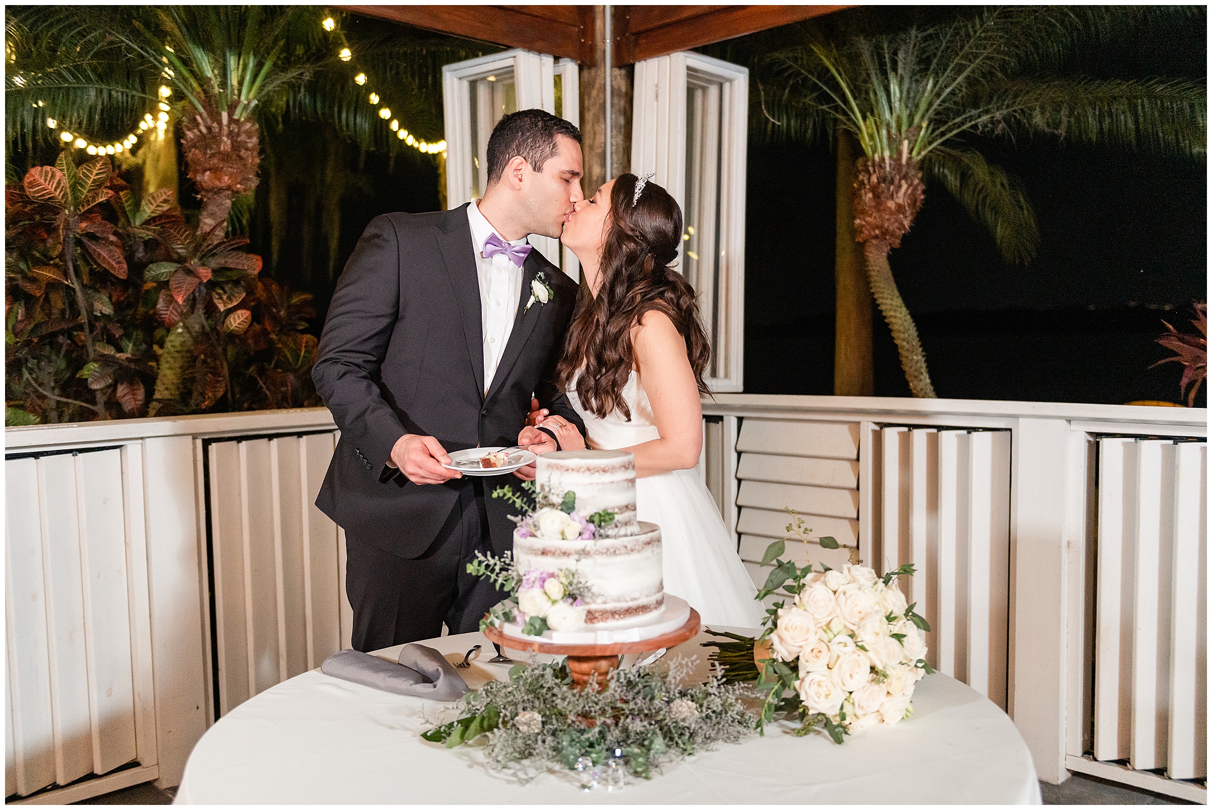 Bride and groom kissing after cutting the wedding cake at their Paradise Cove Wedding in Orlando, FL