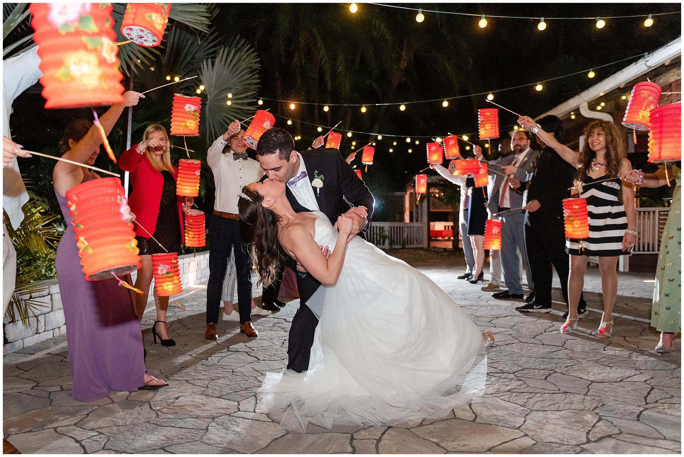 Bride and groom Dipping and kissing during an exit of lanterns at their Paradise Cove Wedding in Orlando, FL