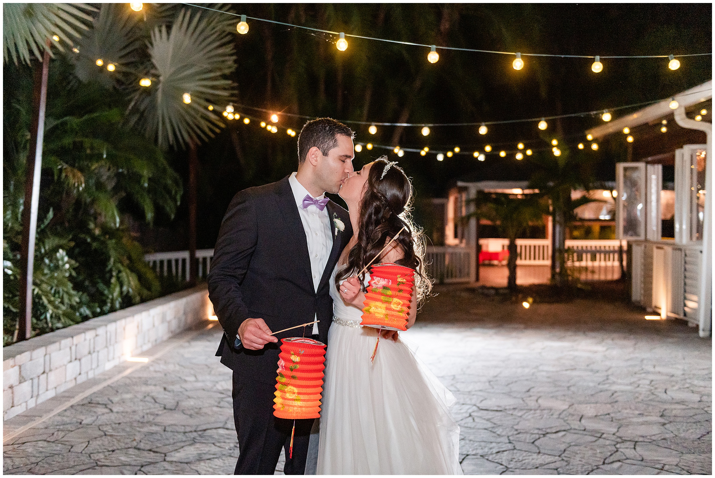 Bride and groom kissing with exit lanterns at their Paradise Cove Wedding in Orlando, FL