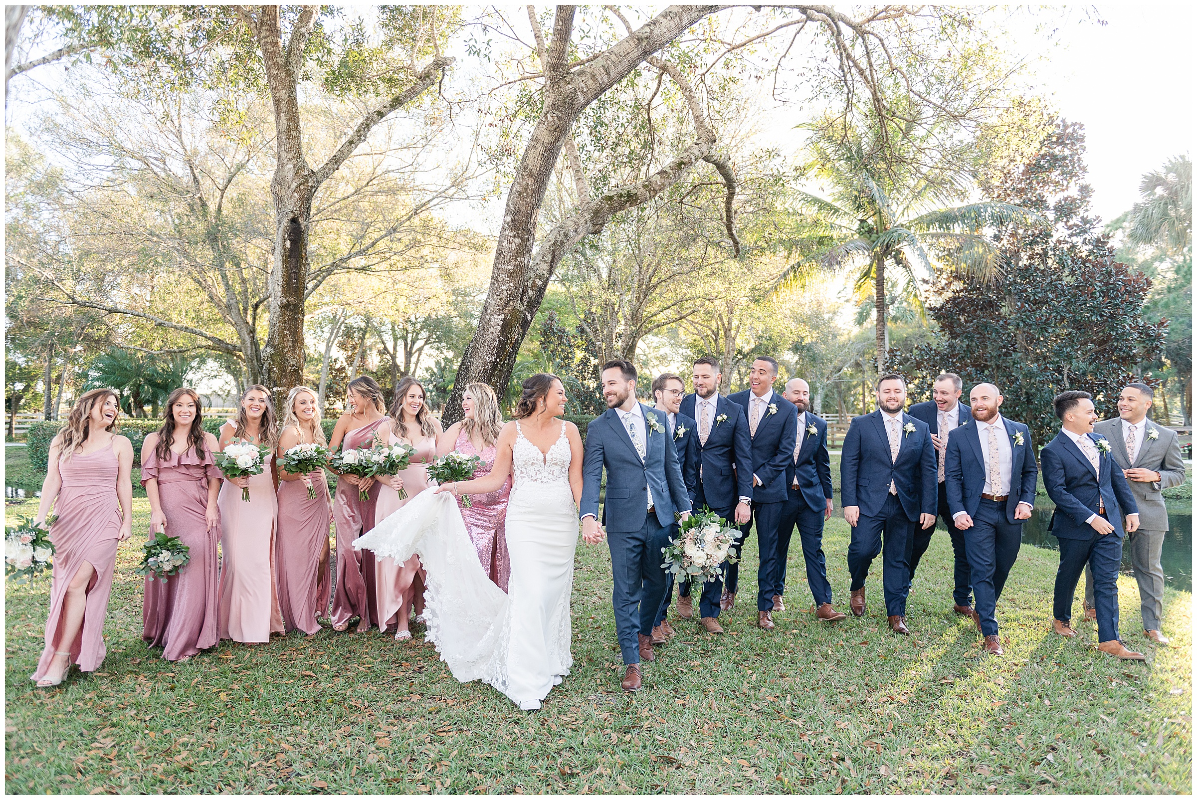 Bridesmaids and groomsmen walking with the bride and groom laughing and talking | Magnolia Manor Wedding in Vero Beach