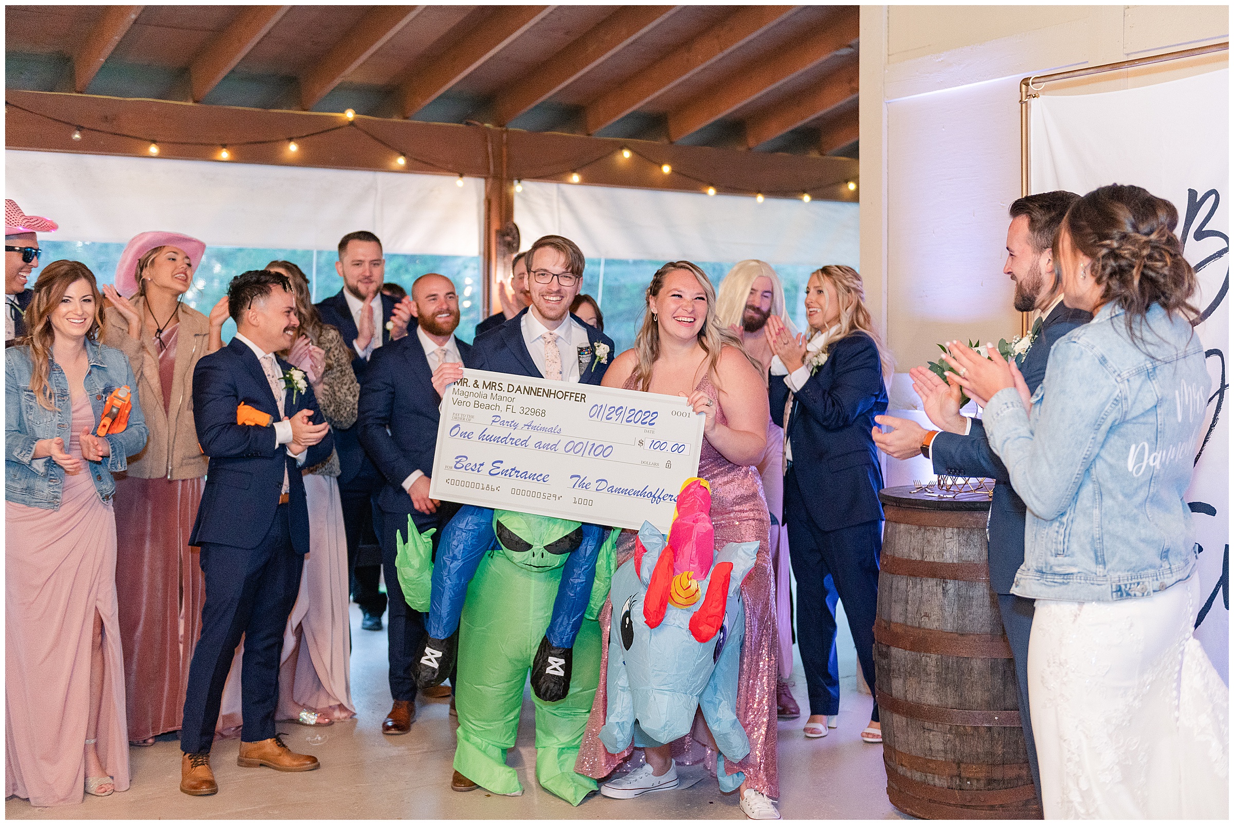 Fun bridal party reception entrance with the bride and groom rewarding a fake check to the best entrance
