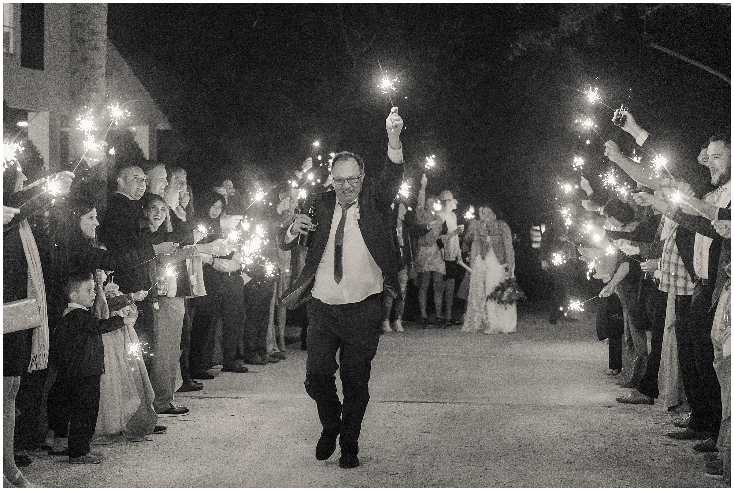 Dad running down the sparkler line to be funny at a wedding reception exit