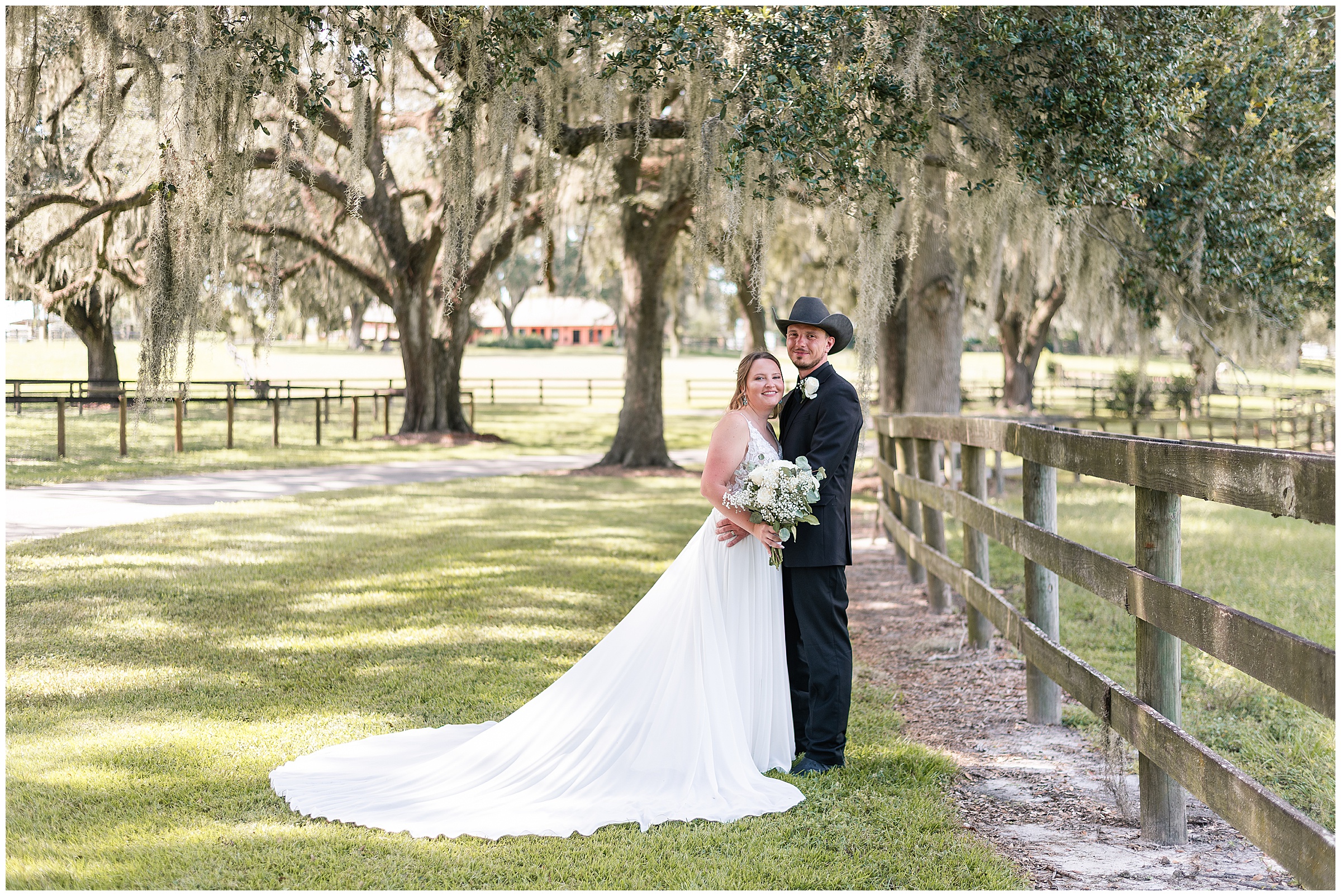 A bride and groom posing underneath oak trees and along a fenceline at their Ocala Wedding at Protea Weddings and Events. 