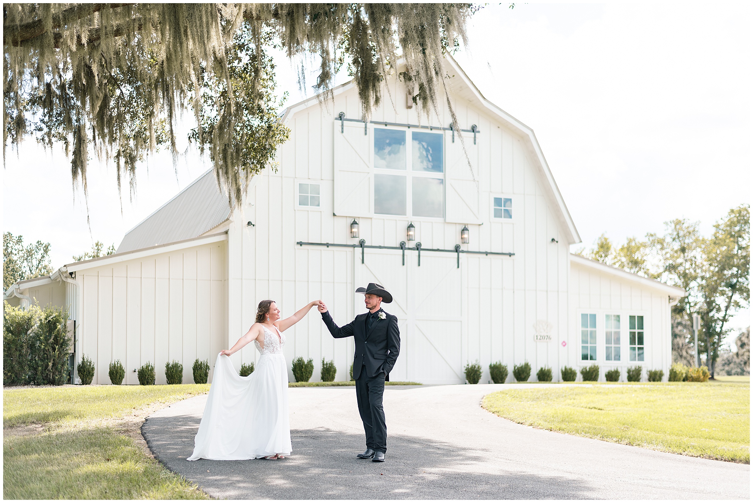A bride and groom dancing in front of the white barn at their Ocala Wedding at Protea Weddings and Events. 