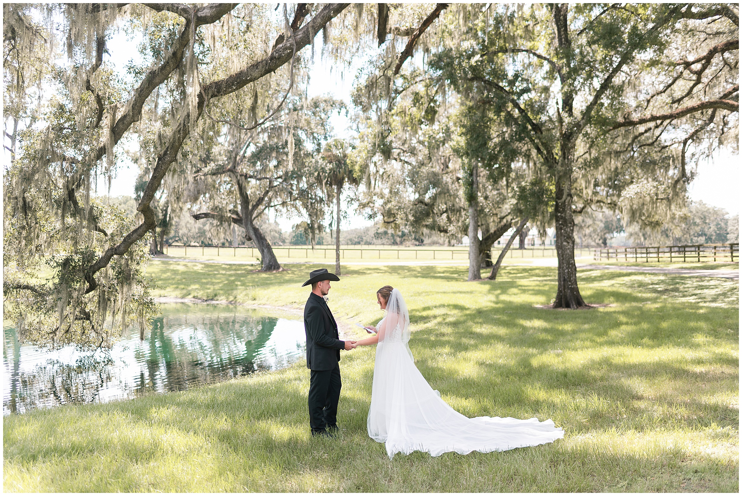 A bride and groom sharing their vows with each other underneath an oak tree near a pond at an Ocala Wedding at Protea Wedding and Events.